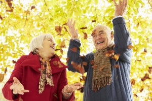 Senior Couple Throwing Leaves Into Air